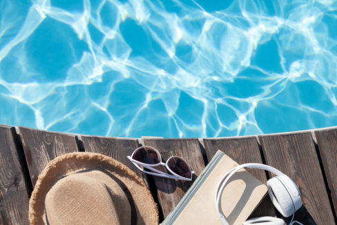 Book and headphones near swimming pool